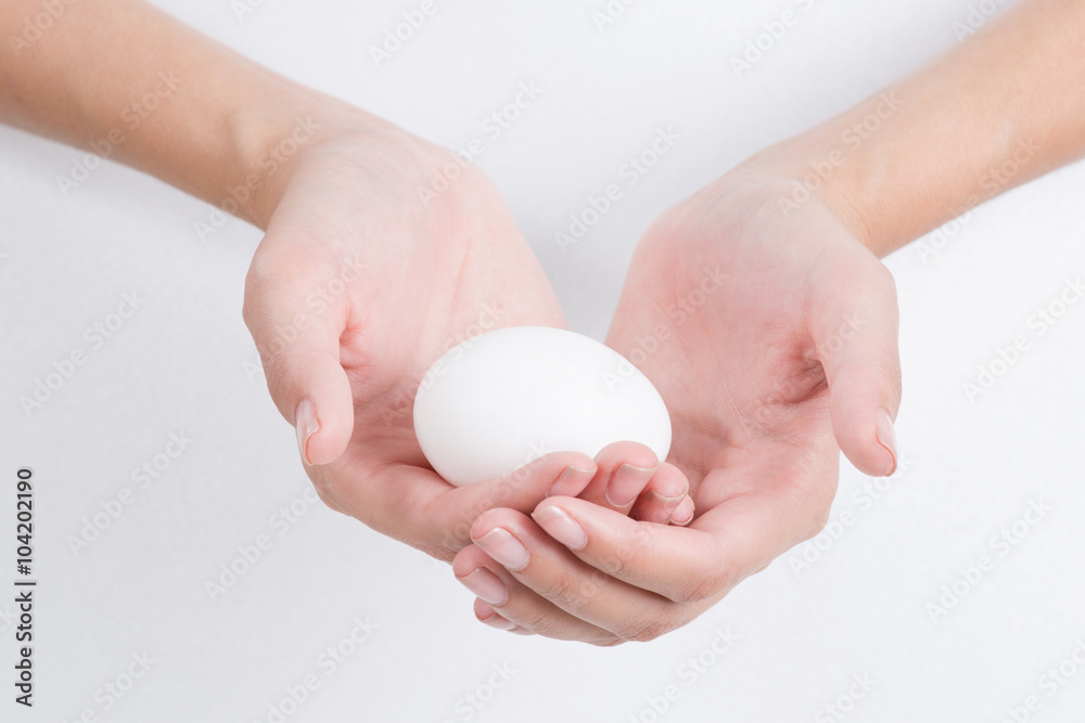 Woman hand holding White egg, isolated on white background Woman hand holding White egg, isolated on white background