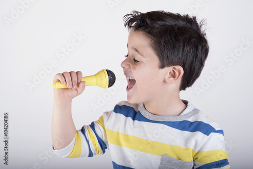 niño cantando con un micrófono  photo