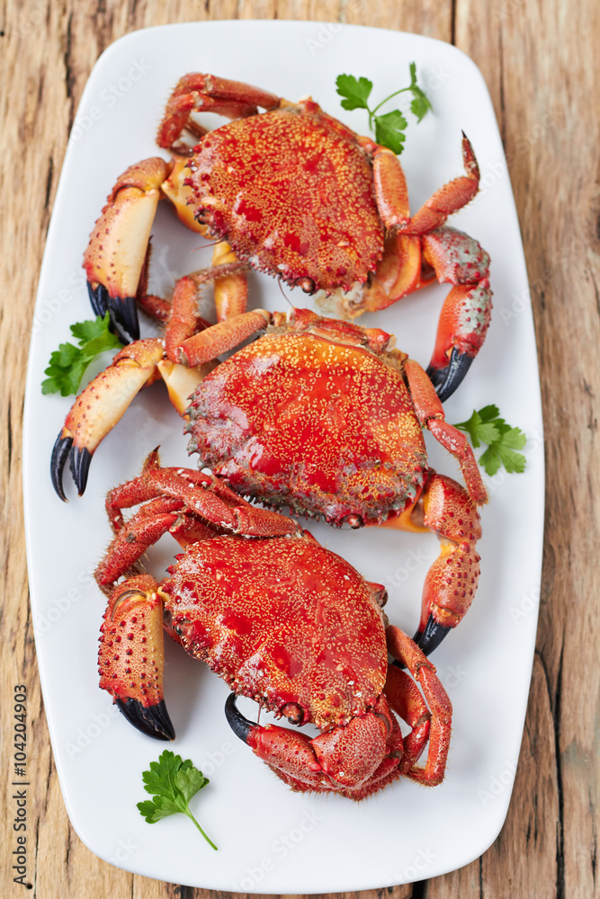 Steamed crabs on appetizer plate with herbs,top view Steamed crabs on appetizer plate with herbs,top view