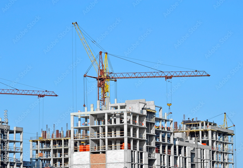 Crane and building construction site against blue sky