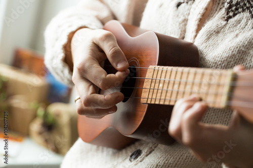 Woman's hand playing ukulele.