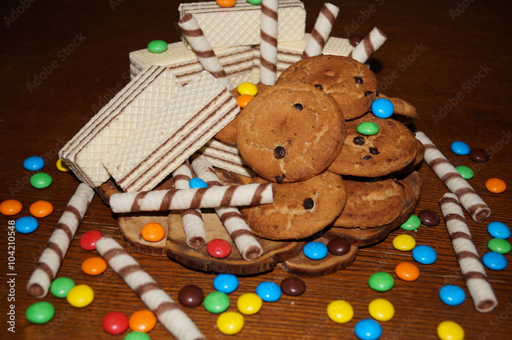 Sweet waffles, biscuits, candies on a wooden table