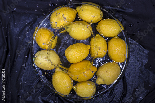 yellow lemonyellow lemon splashing in water on black background photo