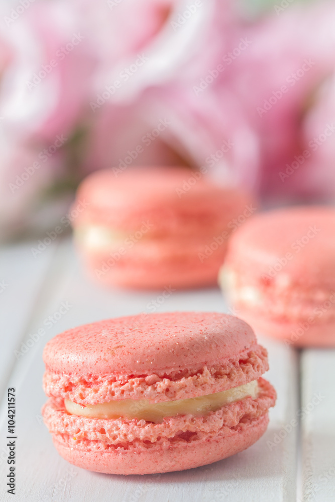 Pink Macarons with Flowers on White Table Vertical