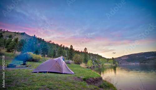 camping site on scenic mountain lake at sunset