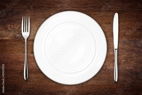 place setting with dish knife and fork on rustic wooden background photo