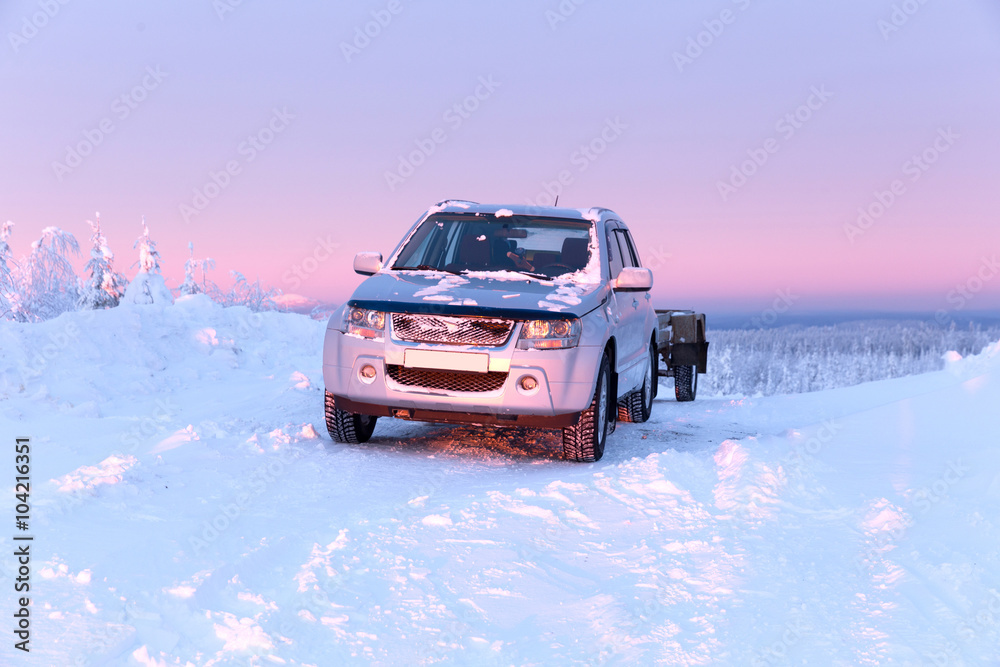 All-terrain vehicle with a trailer on the top of the winter mountains