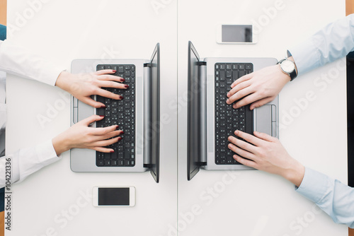 hands working for two laptops