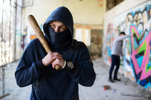 unrecognizable vandal with wooden baseball bat photo