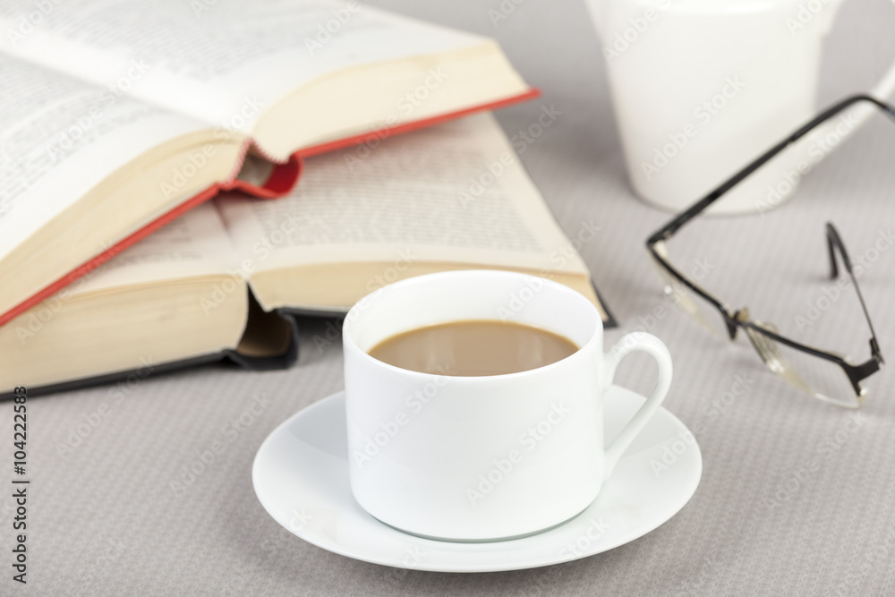 Cup of coffee on the table with two books