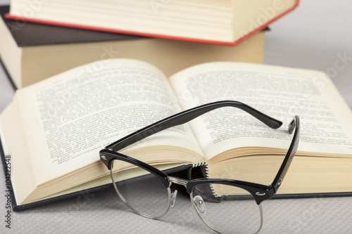 Close up of reading glasses laying on a book