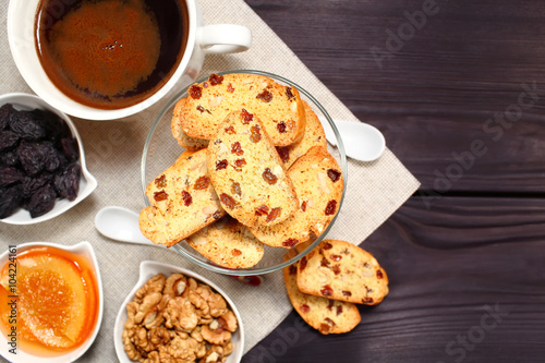 Homemade biscotti are laid out in the form of words next to a large cup of hot black coffee on vintage rustic table