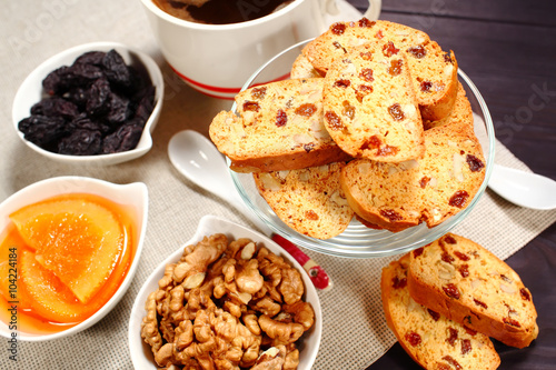 Homemade biscotti are laid out in the form of words next to a large cup of hot black coffee on vintage rustic table