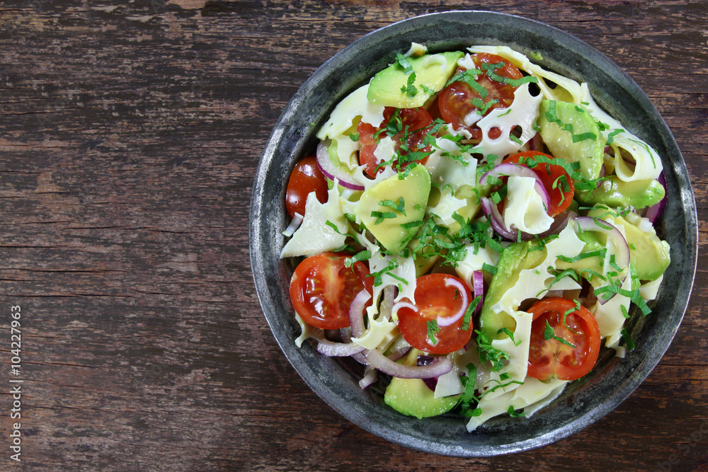 Salad with avocado, cheese, tomato and red onion