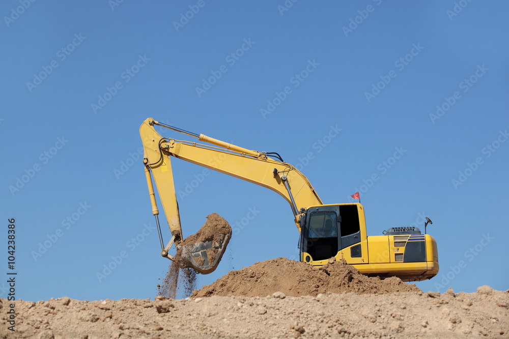 Excavator at a construction site with blue sky