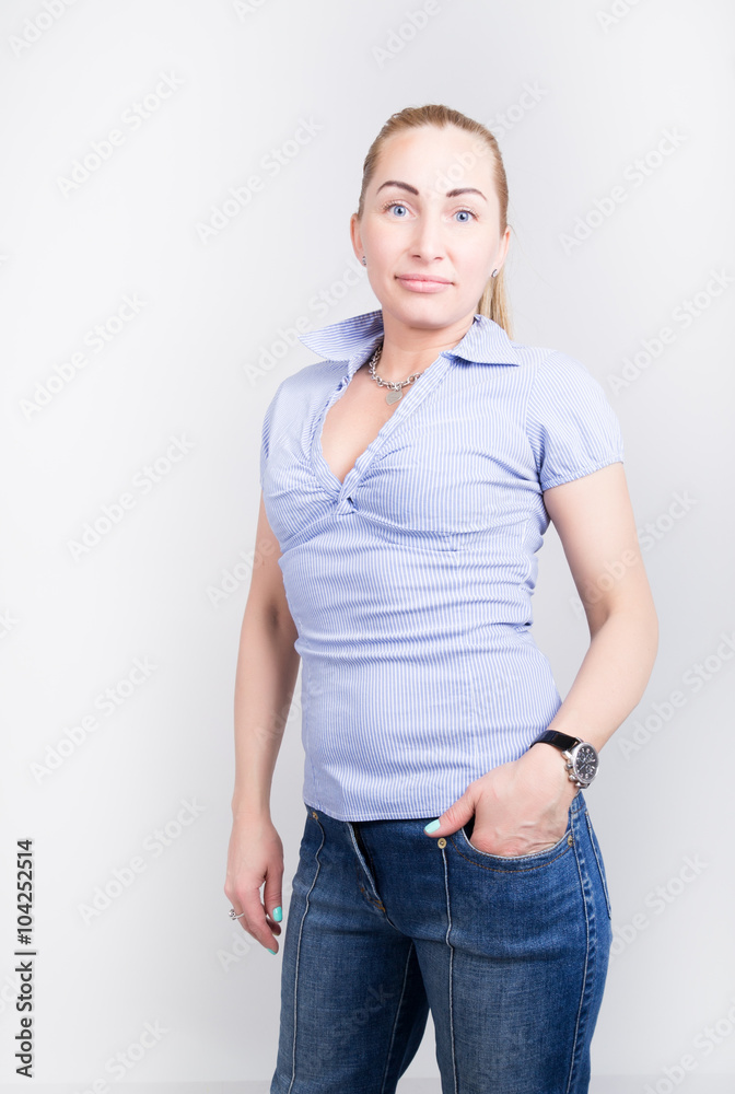 beautiful young leggy blond girl in a jeans and a blue shirt in a boots, full height posing beautiful young leggy blond girl in a jeans and a blue shirt in a boots, full height posing
