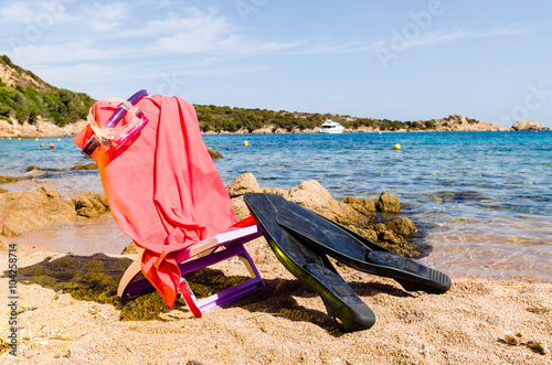 deckchair with diving mask and flipper, on the beach, sunny day.