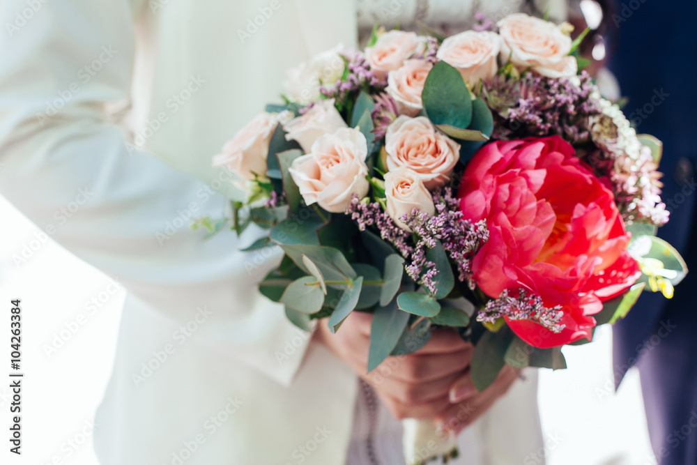 Bride holding wedding bouquet. Beautiful bouquet of roses and pe Bride holding wedding bouquet. Beautiful bouquet of roses and pe