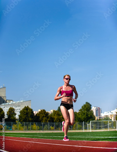 athlete girl running at the stadium