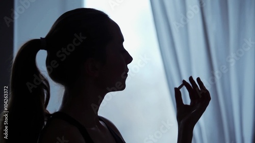 Young woman deliberates whether to take a pill