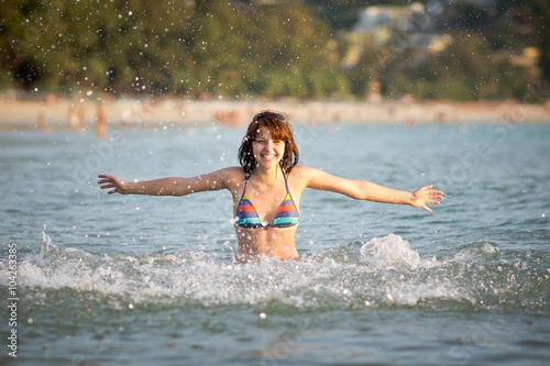 Молодая девушка веселится и брызгается в воде