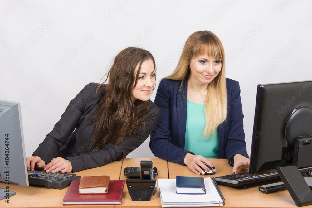 She looked at his colleague computer screen at work in the office She looked at his colleague computer screen at work in the office