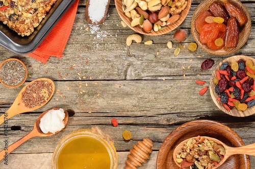 Ingredients for homemade granola bars - dried fruits, nuts, seeds and honey on wooden table.Copyspace background. Top view.