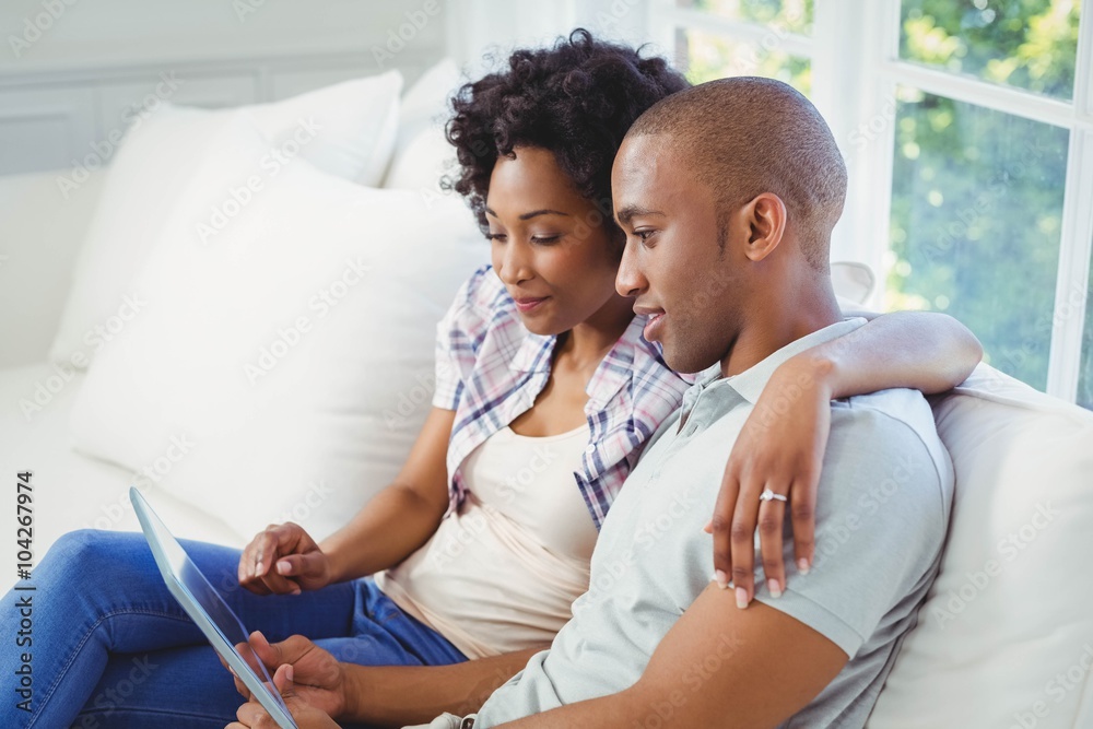Happy couple using tablet on the sofa Happy couple using tablet on the sofa