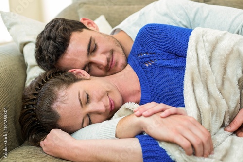 Young couple cuddling on sofa