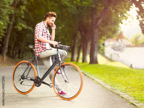 man talking on the phone sitting on bicycle