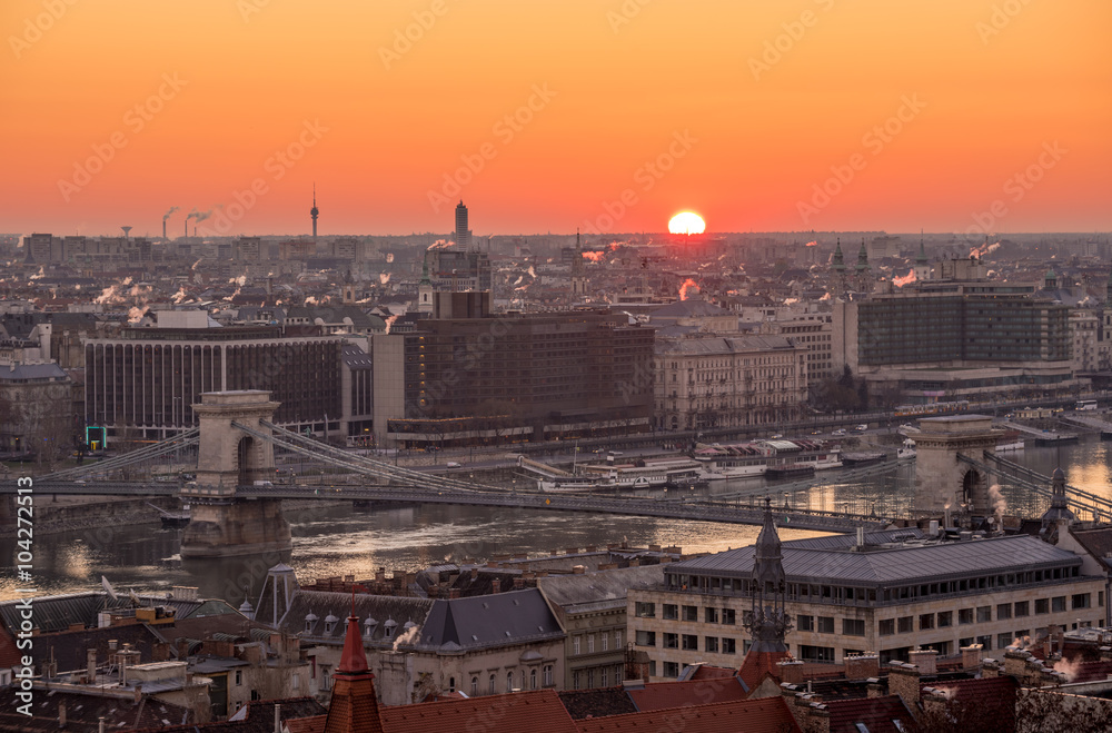 Rising Sun over Cityscape of Budapest with Chain Bridge over Danube River Rising Sun over Cityscape of Budapest with Chain Bridge over Danube River