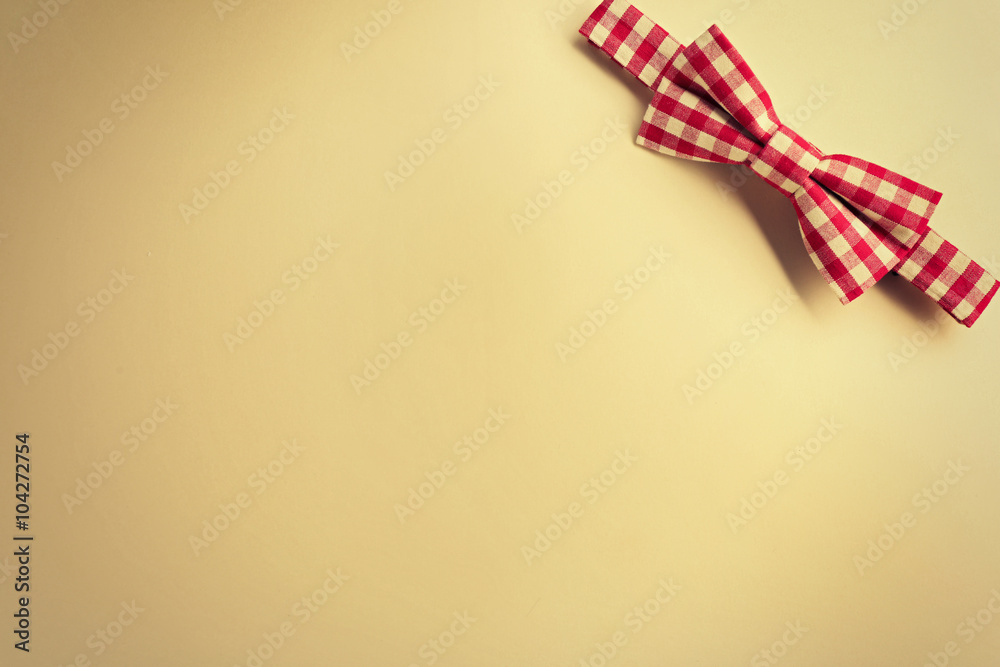 Red cell bow tie on beige background