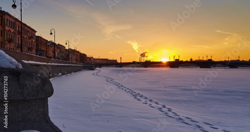 Russia, Saint-Petersburg, 1 March 2016: Blagoveshchenskiy Bridge, Promenade des Anglais, winter sunset, Neva river covered with snow, smoke from the chimneys in the background, traffic, time lapse 4k photo