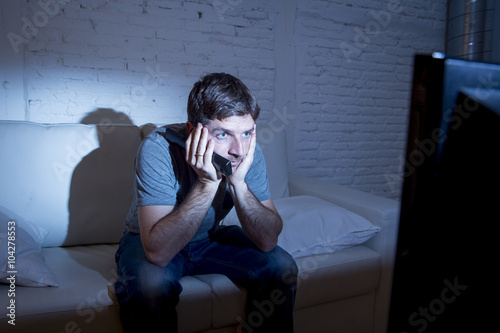 television addict on couch at home watching tv mesmerized