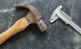 old used hammer and vernier on concrete texture floor background, top view
