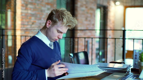 Businessman sitting in the restaurant and reading documents
 photo