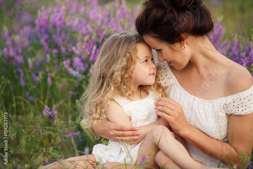 Happy mother and daughter in a field of blooming lavender