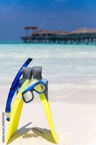 Taucherbrille und Flossen am Malediven Strand stehend