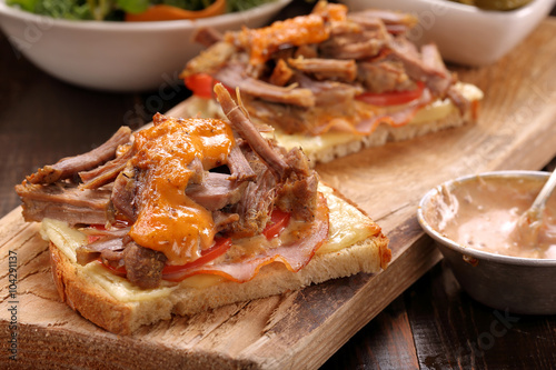 Sandwich with shredded pork on wooden table