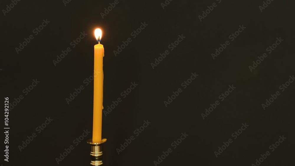 Time-Lapse of flaming yellow candle on black background. Time-Lapse of flaming yellow candle on black background.