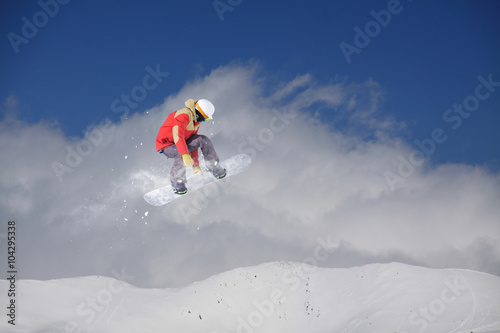 Flying snowboarder on mountains. Extreme sport.