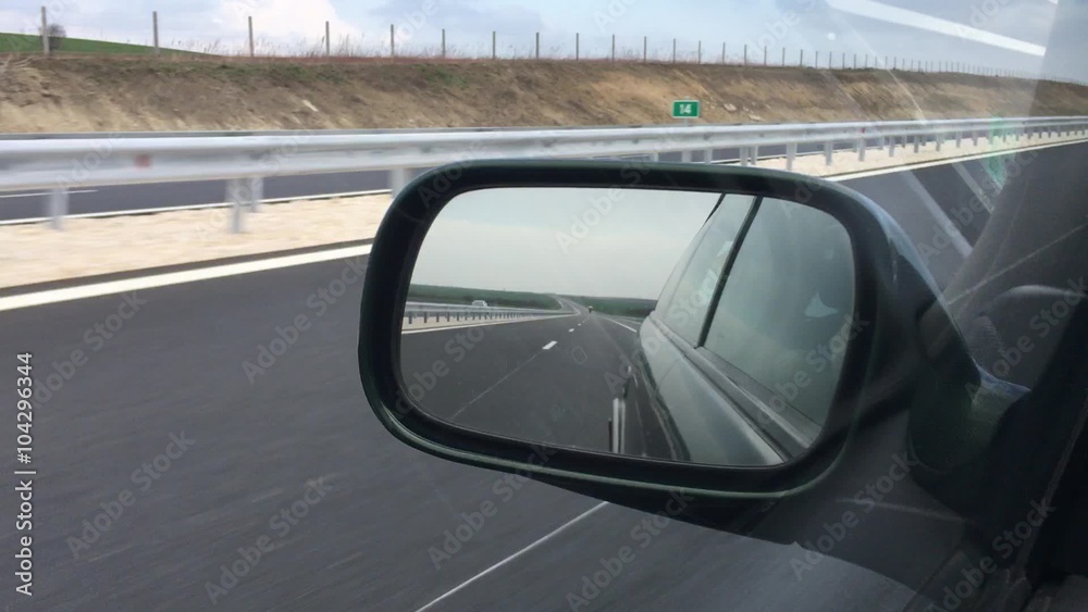 Driving - side mirror view, driving on highway Driving - side mirror view, driving on highway