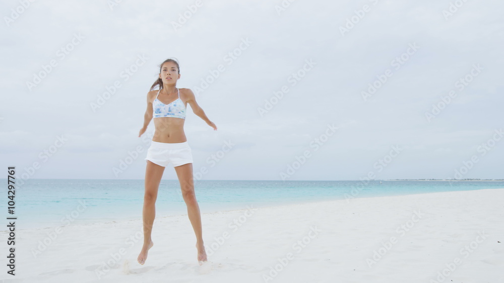Crossfit fitness Asian woman on beach doing Jump Squat plyometrics training exercises for legs, butt, glutes and thighs by jumping as part of a full body core workout and active lifestyle. Jump Squats Crossfit fitness Asian woman on beach doing Jump Squat plyometrics training exercises for legs, butt, glutes and thighs by jumping as part of a full body core workout and active lifestyle. Jump Squats