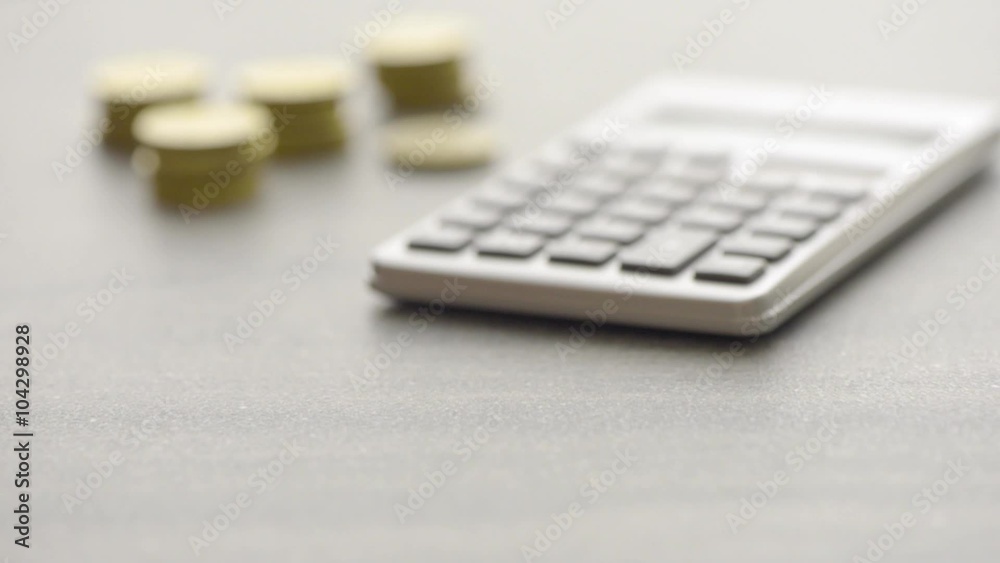 Calculator and coins on office desk. Film clip with slow sliding motion. Concept of economy, budget and home finances. Calculator and coins on office desk. Film clip with slow sliding motion. Concept of economy, budget and home finances.