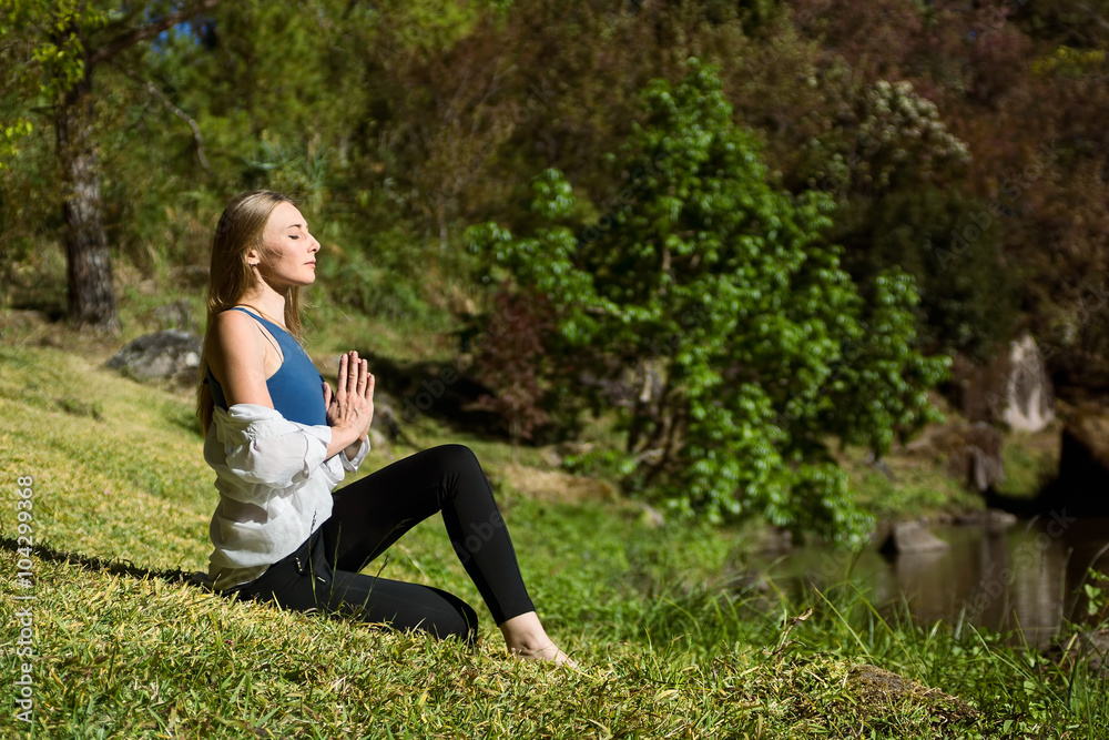 caucasian woman meditate beside river, hands in namaste caucasian woman meditate beside river, hands in namaste