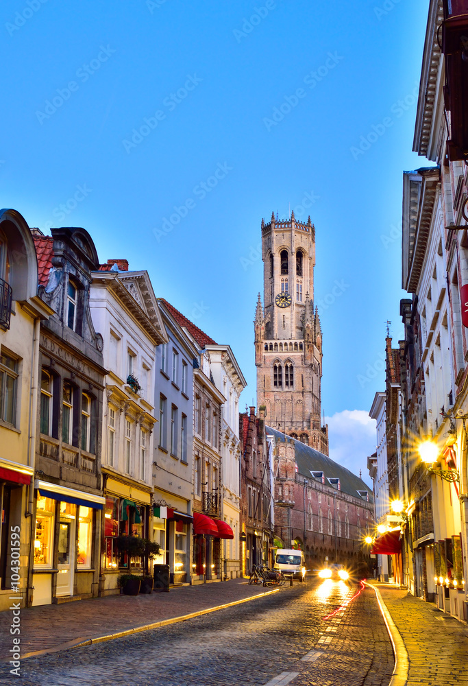 Brugge street and Belfry tower architecture illuminated in evening lights, Belgium