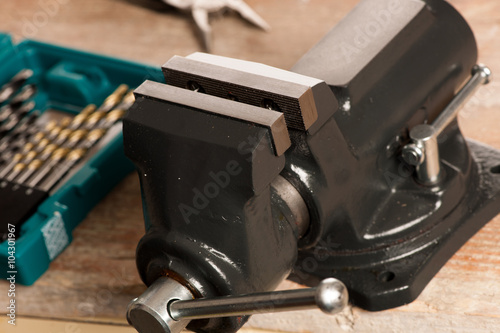Canvas Print Closeup of vice tool clamping device on wooden background.