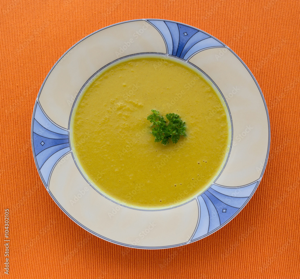 plate of pumpkin soup on orange background plate of pumpkin soup on orange background