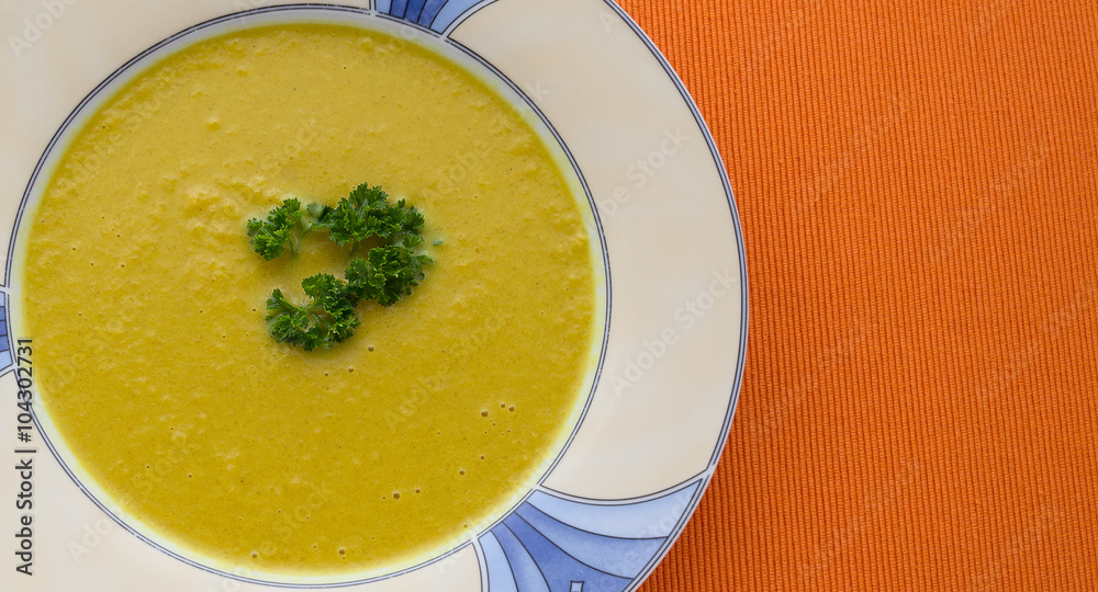 plate of pumpkin soup on orange background plate of pumpkin soup on orange background