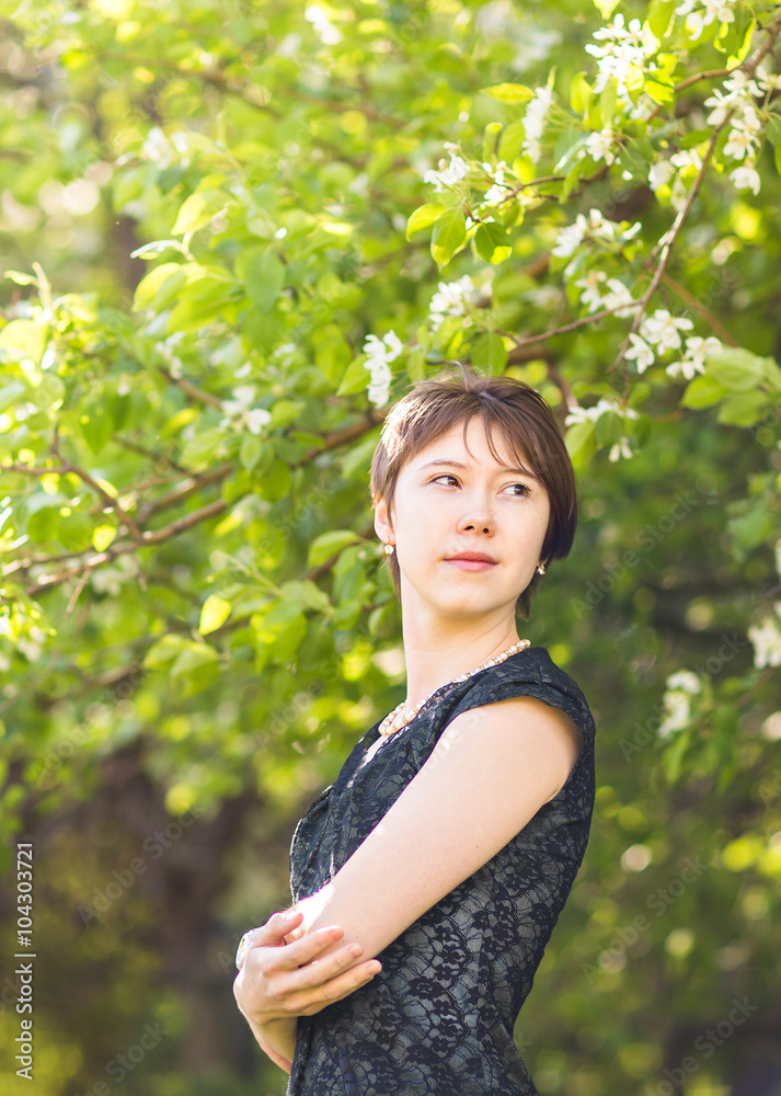 Romantic young woman in the spring garden among apple blossom Romantic young woman in the spring garden among apple blossom